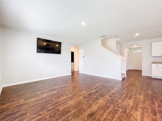 unfurnished living room featuring dark hardwood / wood-style floors and a textured ceiling