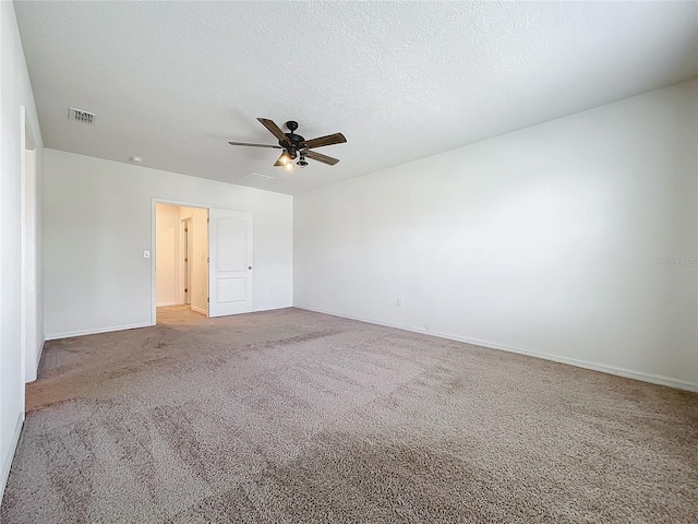 carpeted spare room with ceiling fan and a textured ceiling