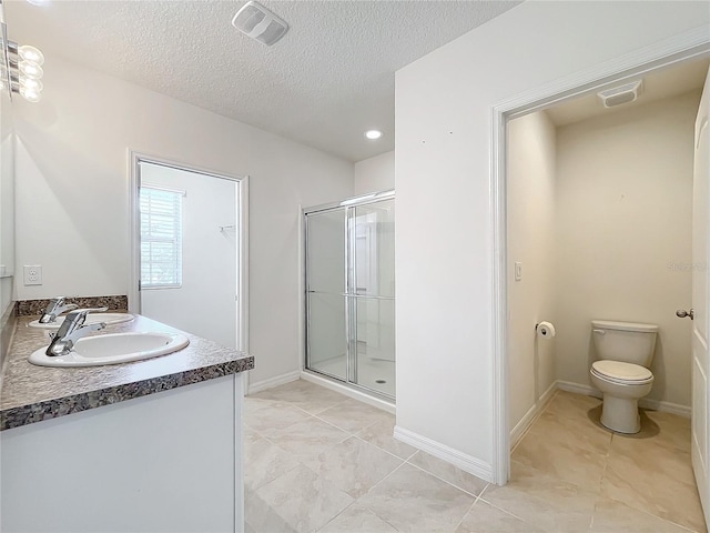 bathroom featuring an enclosed shower, vanity, toilet, and a textured ceiling