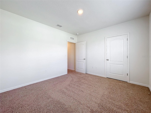 unfurnished bedroom with carpet floors and a textured ceiling