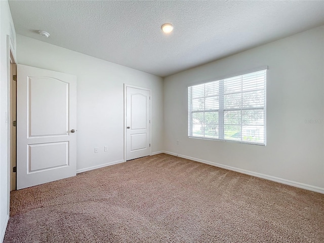 unfurnished bedroom with carpet flooring, a closet, and a textured ceiling