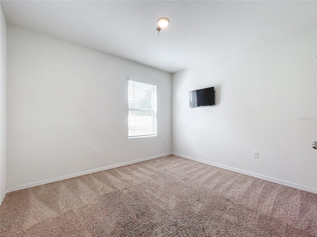 carpeted empty room featuring a textured ceiling