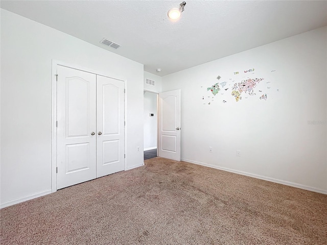 unfurnished bedroom featuring carpet and a closet