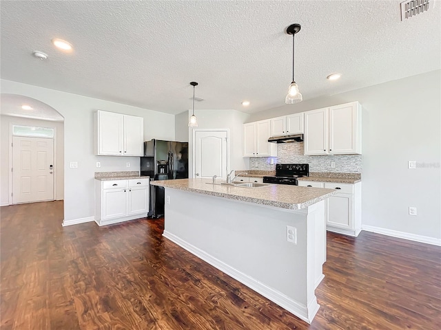 kitchen featuring white cabinets, dark hardwood / wood-style floors, a center island with sink, and black appliances