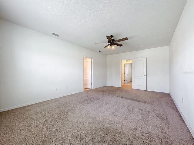 carpeted empty room with ceiling fan and a textured ceiling