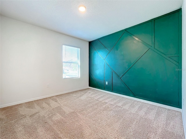 carpeted empty room featuring a textured ceiling