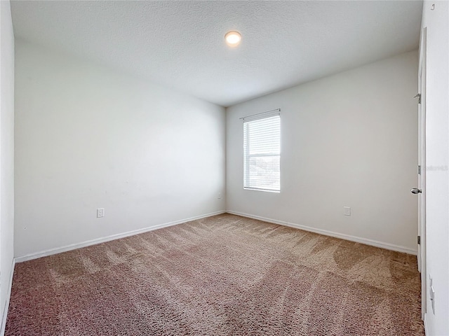 carpeted empty room featuring a textured ceiling