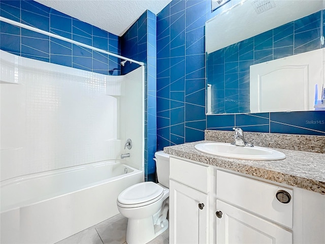 full bathroom featuring tile walls, tile patterned flooring, a textured ceiling, and washtub / shower combination