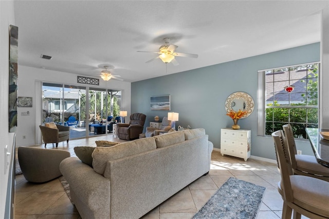 tiled living room with a wealth of natural light and ceiling fan