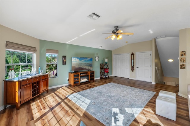 living room with ceiling fan, light hardwood / wood-style flooring, and lofted ceiling