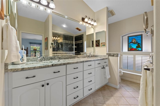 bathroom featuring tile patterned flooring, vanity, vaulted ceiling, and walk in shower