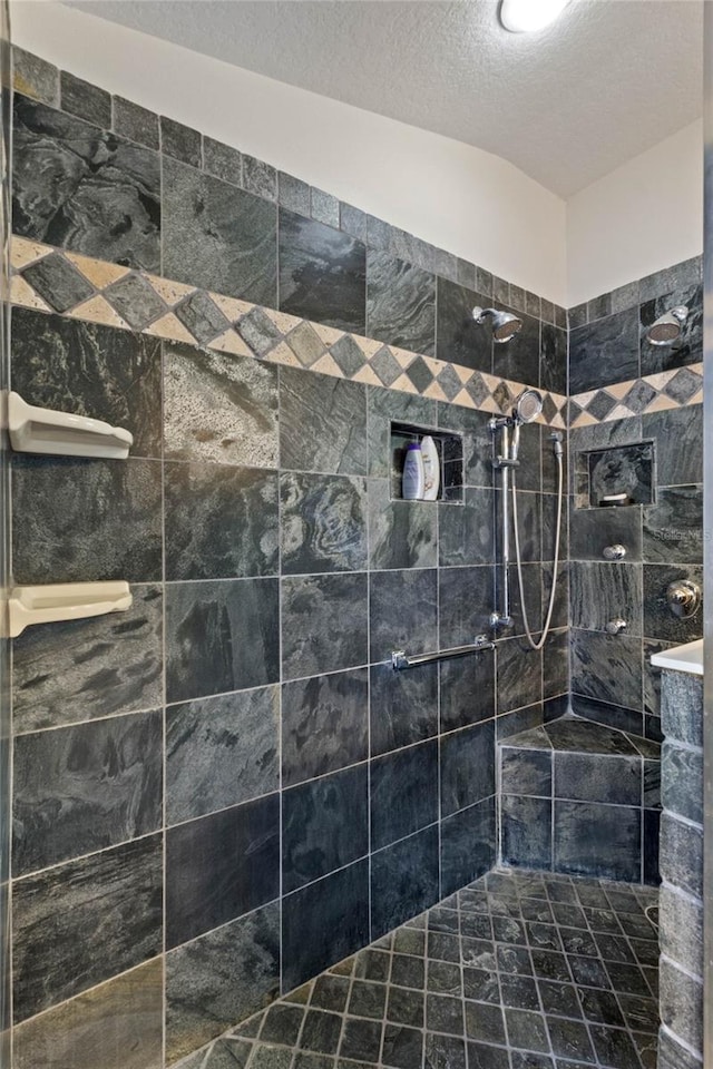 bathroom featuring a tile shower and a textured ceiling