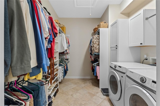 clothes washing area featuring cabinets and washing machine and dryer