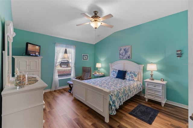 bedroom featuring dark hardwood / wood-style flooring, vaulted ceiling, and ceiling fan