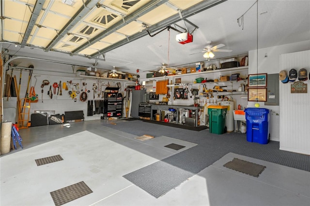 garage featuring a workshop area, a garage door opener, and ceiling fan