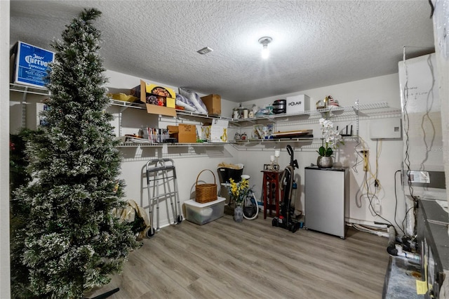 laundry room with a textured ceiling and light wood-type flooring