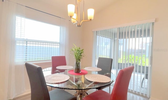 dining space with vaulted ceiling and a chandelier