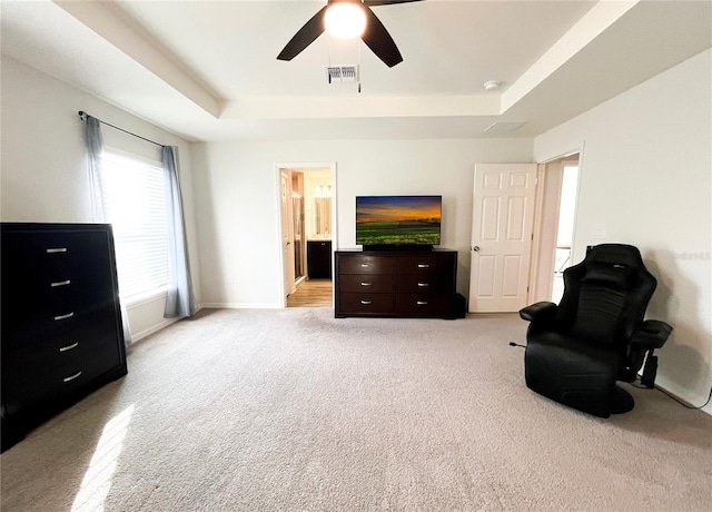 sitting room with light colored carpet, a raised ceiling, and ceiling fan