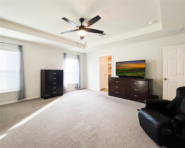 sitting room featuring light carpet, a raised ceiling, and ceiling fan