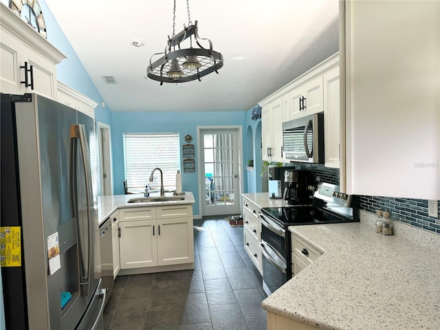 kitchen with white cabinetry, sink, lofted ceiling, decorative light fixtures, and appliances with stainless steel finishes