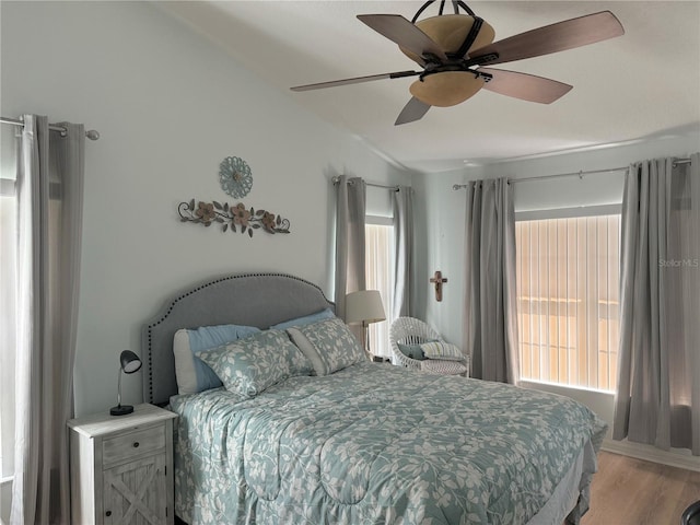 bedroom with light hardwood / wood-style floors, ceiling fan, and lofted ceiling