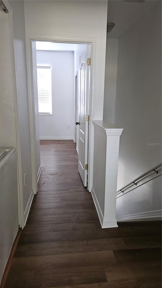 652 Chelsea Dr, Davenport, FL 33897 - corridor featuring baseboards, dark wood-type flooring, and an upstairs landing