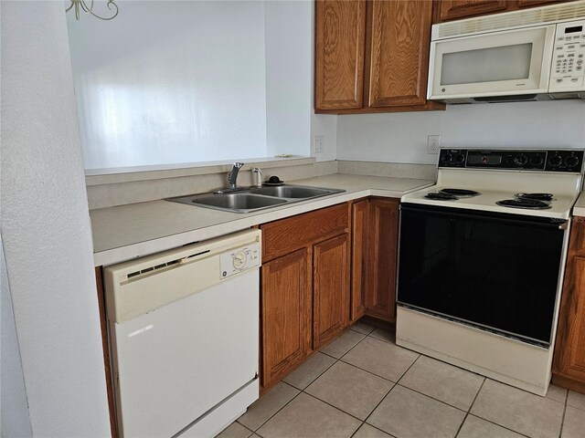 652 Chelsea Dr, Davenport, FL 33897 - kitchen with white appliances, a sink, brown cabinetry, light countertops, and light tile patterned floors