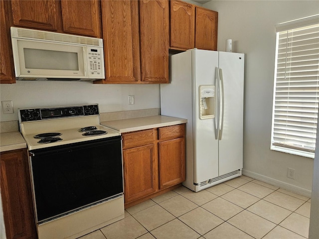 kitchen featuring light tile patterned floors and white appliances