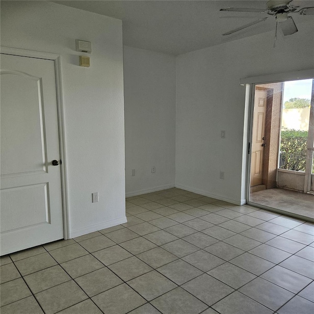 tiled spare room featuring ceiling fan