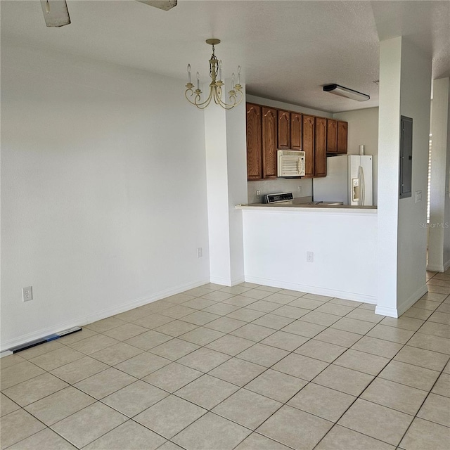 kitchen featuring white appliances, electric panel, decorative light fixtures, light tile patterned floors, and a notable chandelier