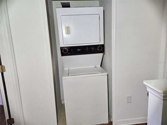 652 Chelsea Dr, Davenport, FL 33897 - washroom with stacked washing machine and dryer and baseboards