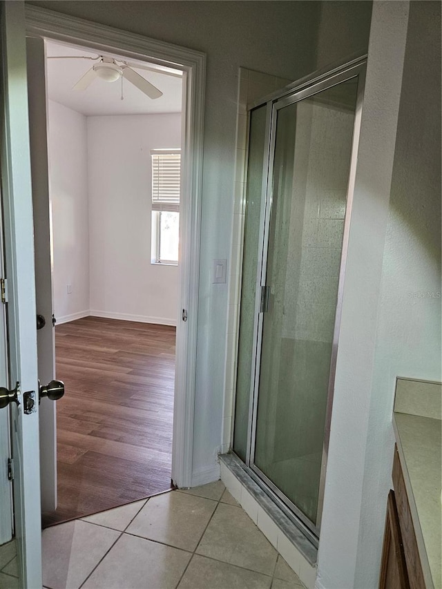 bathroom featuring ceiling fan, wood-type flooring, and walk in shower