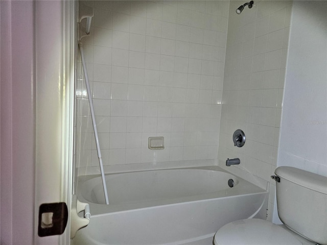 bathroom featuring tiled shower / bath and toilet