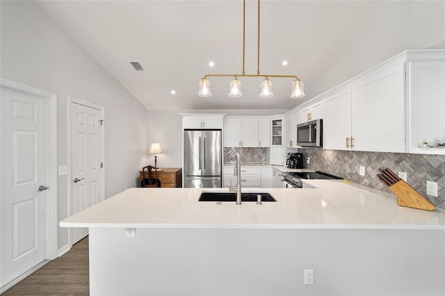 kitchen featuring sink, hanging light fixtures, vaulted ceiling, and appliances with stainless steel finishes