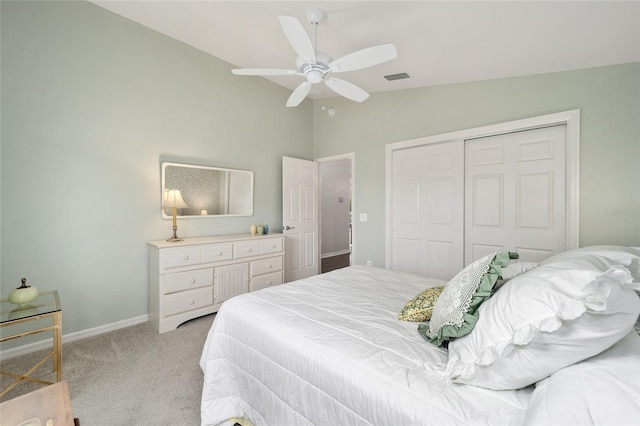 bedroom featuring ceiling fan, vaulted ceiling, light colored carpet, and a closet