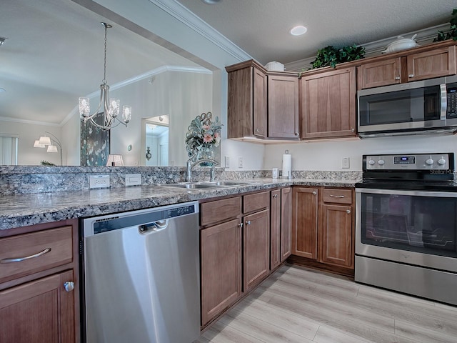 kitchen featuring ornamental molding, stainless steel appliances, sink, light hardwood / wood-style floors, and a chandelier