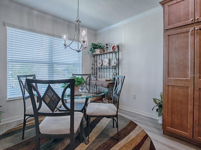 dining room featuring an inviting chandelier, light wood-type flooring, a textured ceiling, and crown molding