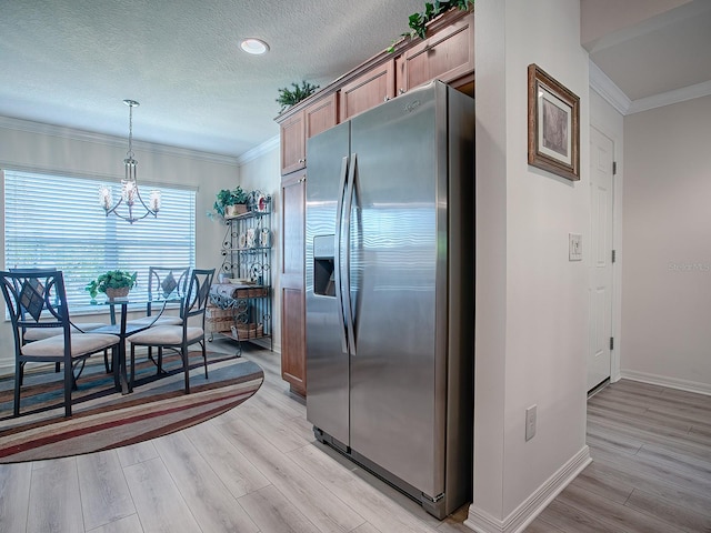 kitchen featuring light wood-type flooring, stainless steel refrigerator with ice dispenser, ornamental molding, and hanging light fixtures