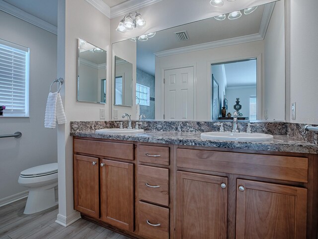 bathroom featuring toilet, vanity, hardwood / wood-style flooring, and crown molding