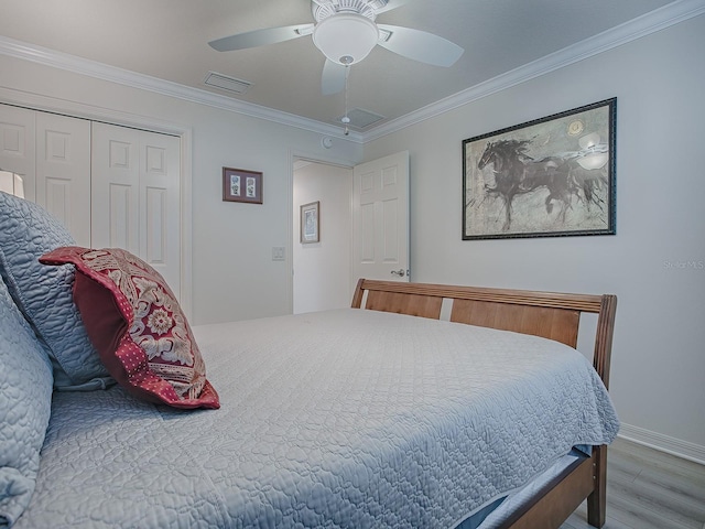 bedroom featuring ornamental molding, hardwood / wood-style floors, ceiling fan, and a closet