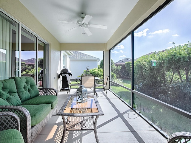 sunroom featuring ceiling fan and a mountain view