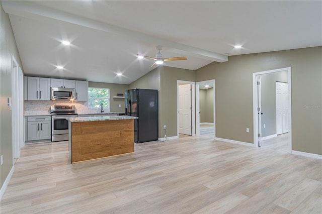 kitchen featuring appliances with stainless steel finishes, light hardwood / wood-style floors, lofted ceiling with beams, a center island, and gray cabinets