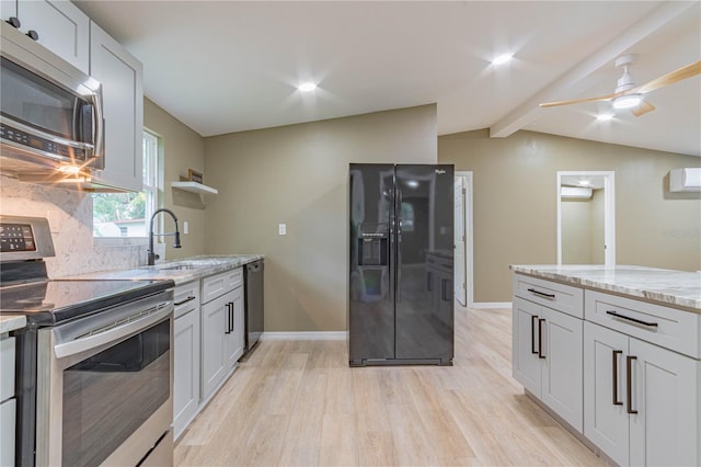 kitchen featuring light stone countertops, sink, stainless steel appliances, lofted ceiling with beams, and light wood-type flooring