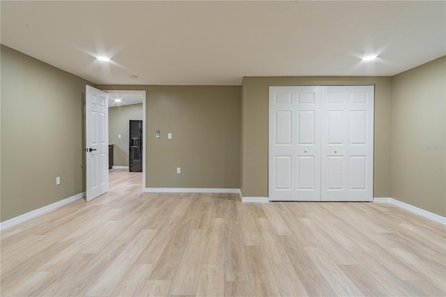 unfurnished bedroom with light hardwood / wood-style flooring and a closet