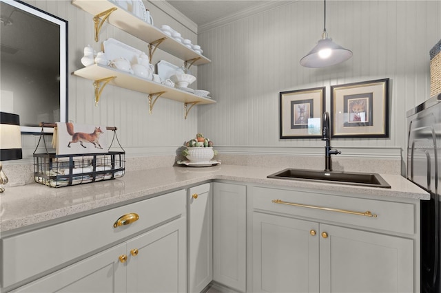 kitchen featuring white cabinetry, crown molding, sink, and hanging light fixtures