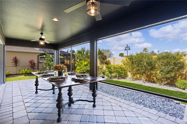 unfurnished sunroom featuring ceiling fan