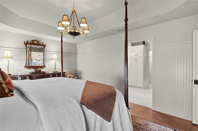 bedroom with hardwood / wood-style flooring and a chandelier