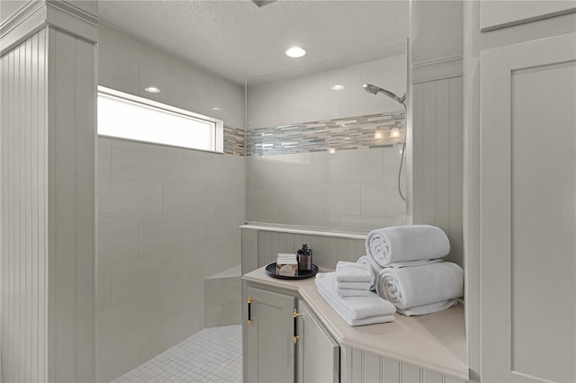 bathroom with walk in shower, a textured ceiling, and recessed lighting