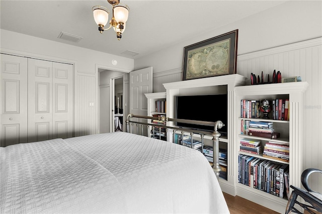 bedroom featuring a chandelier, hardwood / wood-style floors, and a closet