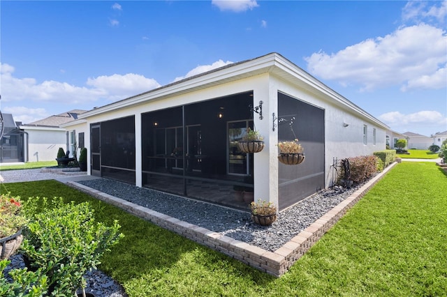 view of home's exterior featuring a sunroom and a lawn